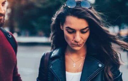 Mann und Frau stehen unglücklich nebeneinander weil die Beziehung durch einen Trennungsgrund kaputt gegangen ist