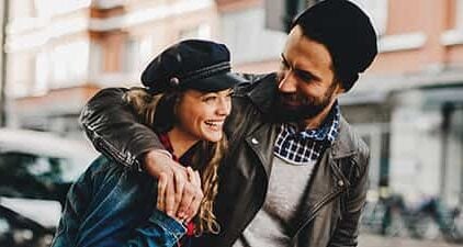 Mann lächelt und umarmt Frau - er kann Frauen zum lachen bringen