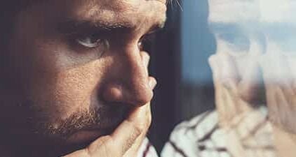 Trennung verarbeiten: Mann schaut nachdenklich aus dem Fenster