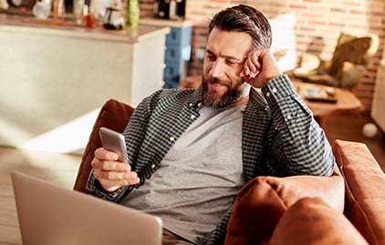 Ein Mann guckt auf sein Handy und lacht