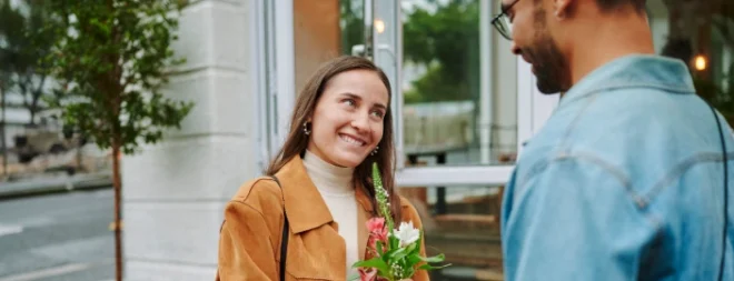 Eine Frau bringt einem Mann einen Blumenstrauß zum zweiten Date mit.