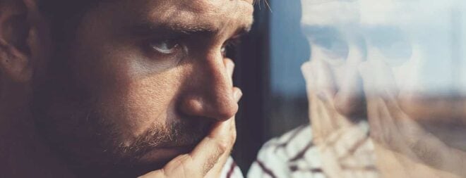 Trennung verarbeiten: Mann schaut nachdenklich aus dem Fenster